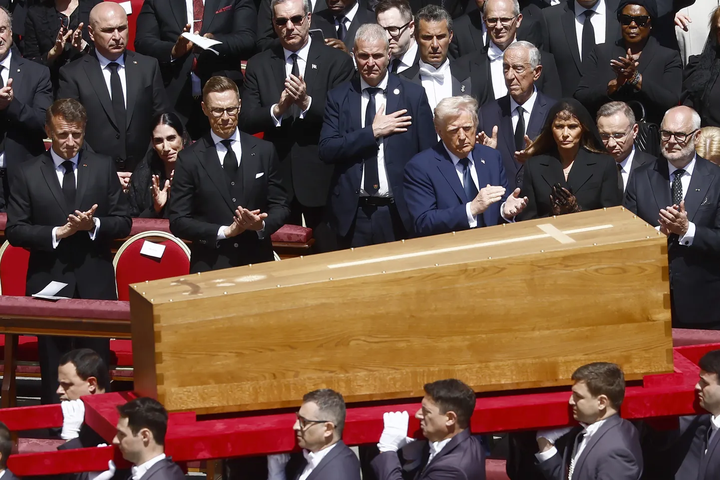 Pāvesta Franciska zārku nes augstu amatpersonu, tostarp ASV prezidenta Donalda Trampa un Francijas prezidenta Emanuela Makrona, priekšā viņa bēru laikā Svētā Pētera laukumā Vatikānā, sestdien, 2025. gada 26. aprīlī.