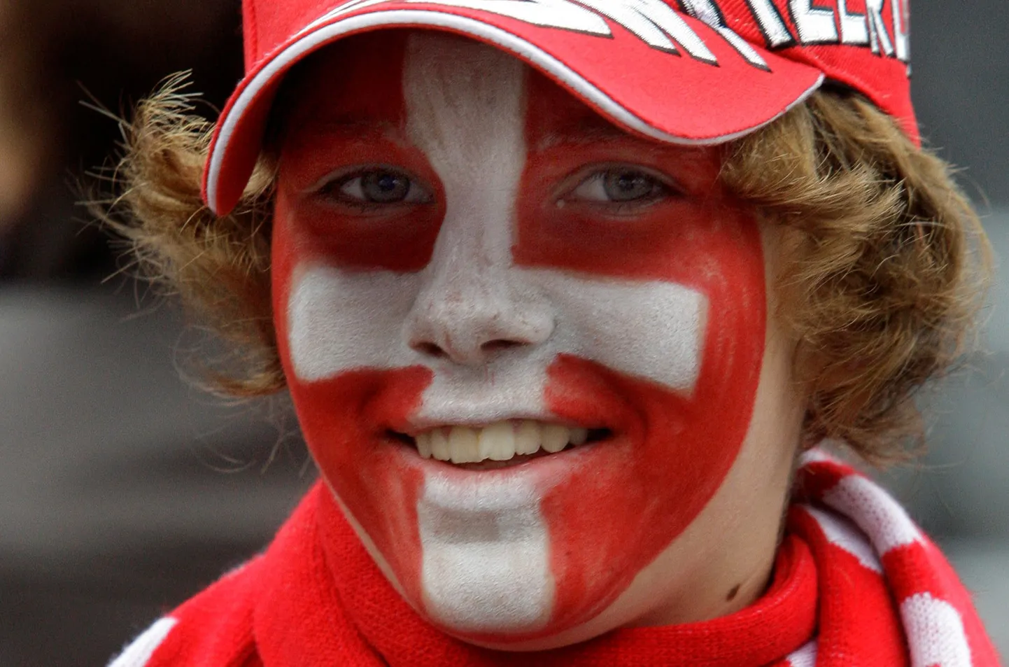 A young Swiss fan with his face painted as the national flag smiles at the fan zone in downtown Basel, Switzerland, Friday, June 6, 2008, where the Euro 2008 European Soccer Championships will start on Saturday with a match between Switzerland and Czech Republic. (AP Photo/Ivan Sekretarev) / SCANPIX Code: 436