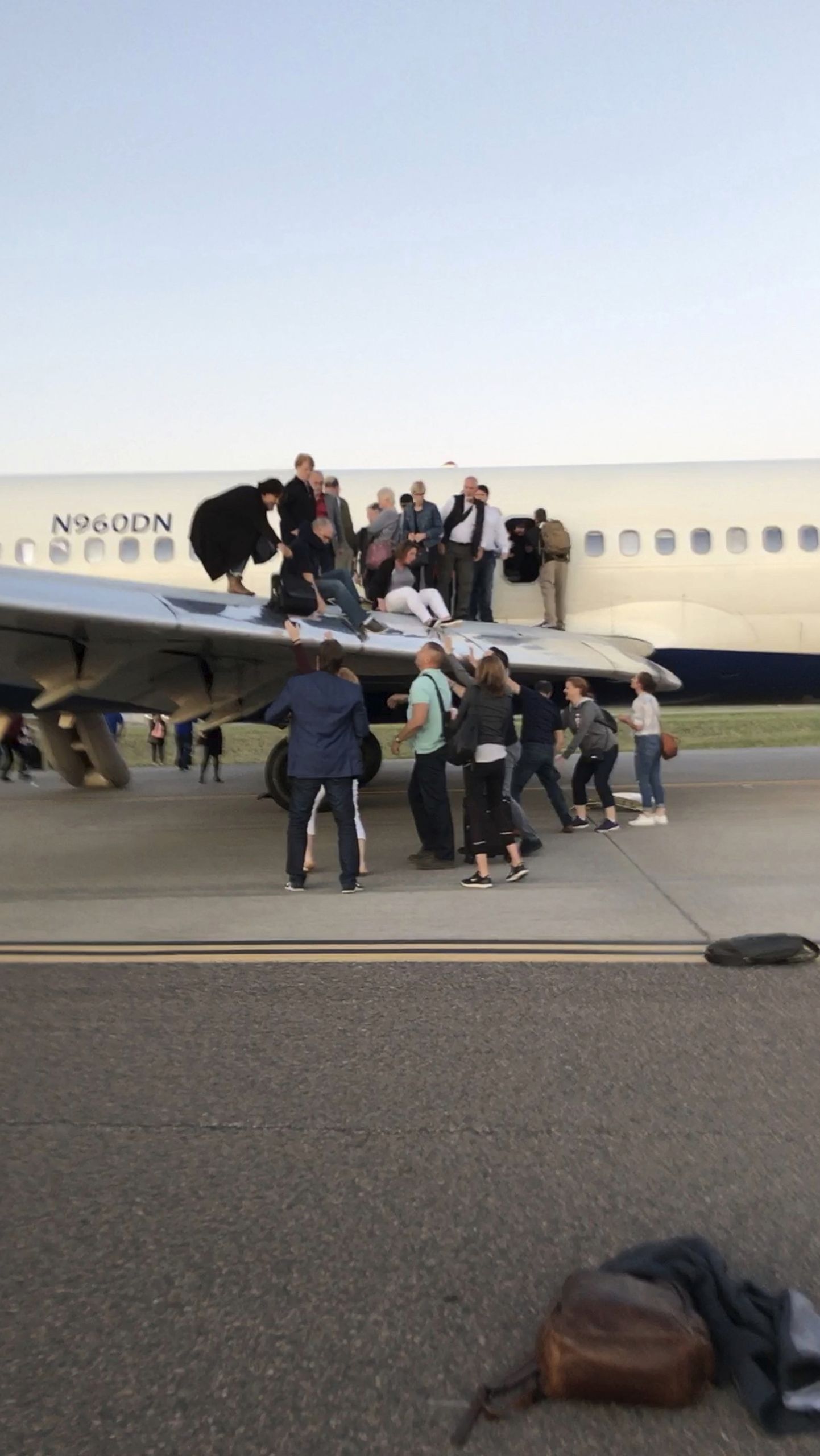 Reisijad väljuvad suitsuga täitunud lennukist tiiba pidi
