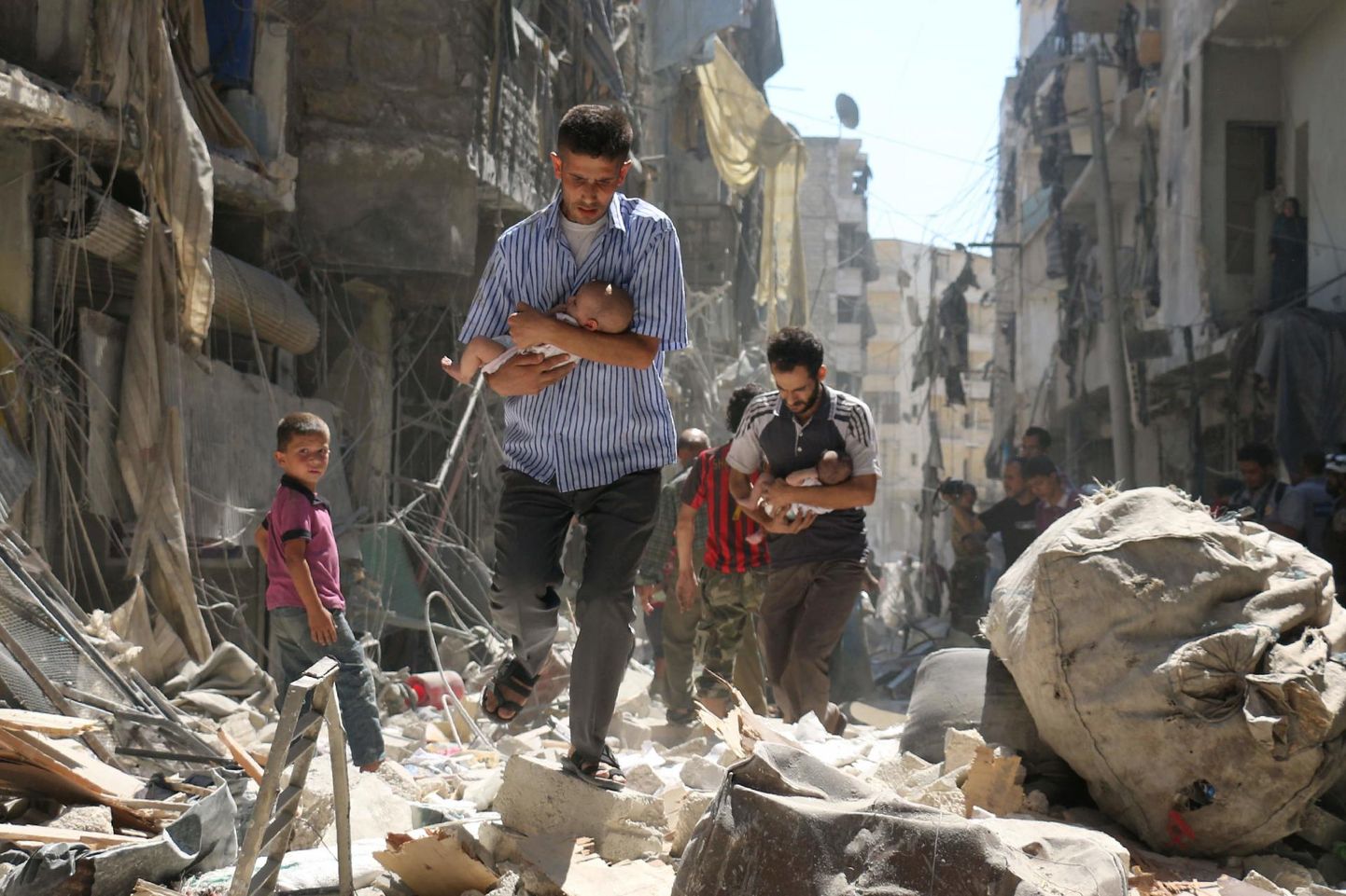 Süüria mehed kannavad Aleppo naabruskonnas läinud aastal Vene õhurünnakute järel majarusude vahel imikuid välja.