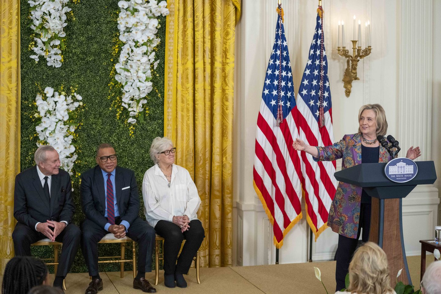 Bijusī ASV valsts sekretāre Hilarija Klintone uzrunā klātesošos svinīgajā pasākumā, lai atzīmētu 2023. gada globālās mākslas balvas "Praemium Imperiale" laureātus. Baltā nama Austrumu spārns, otrdiena, 12. septembris, Vašingtonā. Trīs no šī gada balvas saņēmējiem ir Roberts Vilsons (pa kreisi), Vintons Marsālis un Vija Celmiņa.