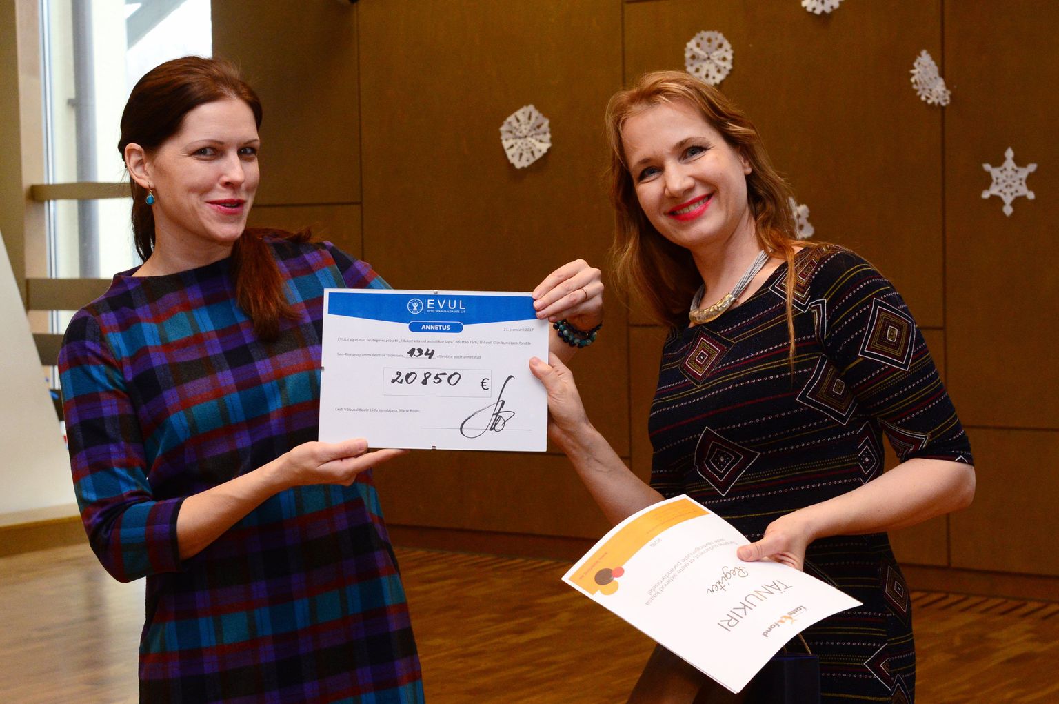 Eesti võlausaldajate liidu juht Marie Rosin (paremal) andis Tartu lastefondi strateegia­juhile Küllike Saarele üle Eesti ettevõtjate suure annetuse.