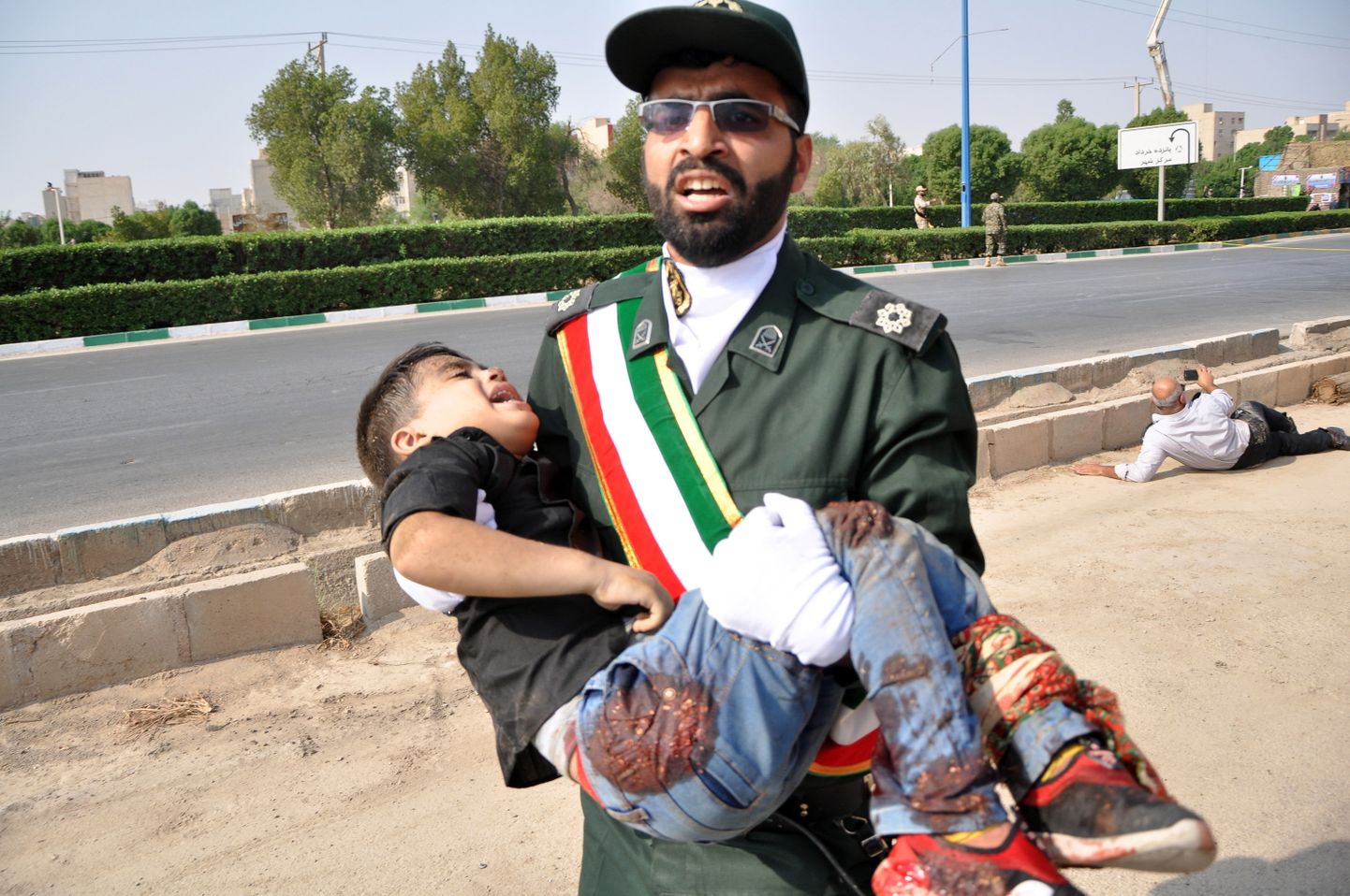 Iraani sõdur kandmas süles täna Ahvazi linnas sõjaväeparaadi ajal toimunud rünnakus vigastada saanud last.
