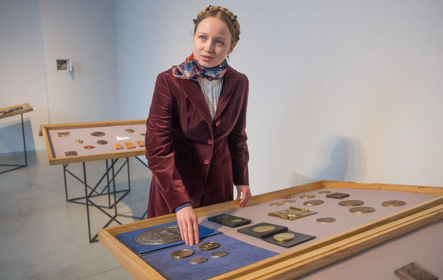 Lina Kalinauskaitė tutvustab näitust. Parema käe sõrmeotsad on ta enda 
uusimal medalil, mille lähedale on välja pandud tema isa Juozas 
Kalinauskase loomingut.