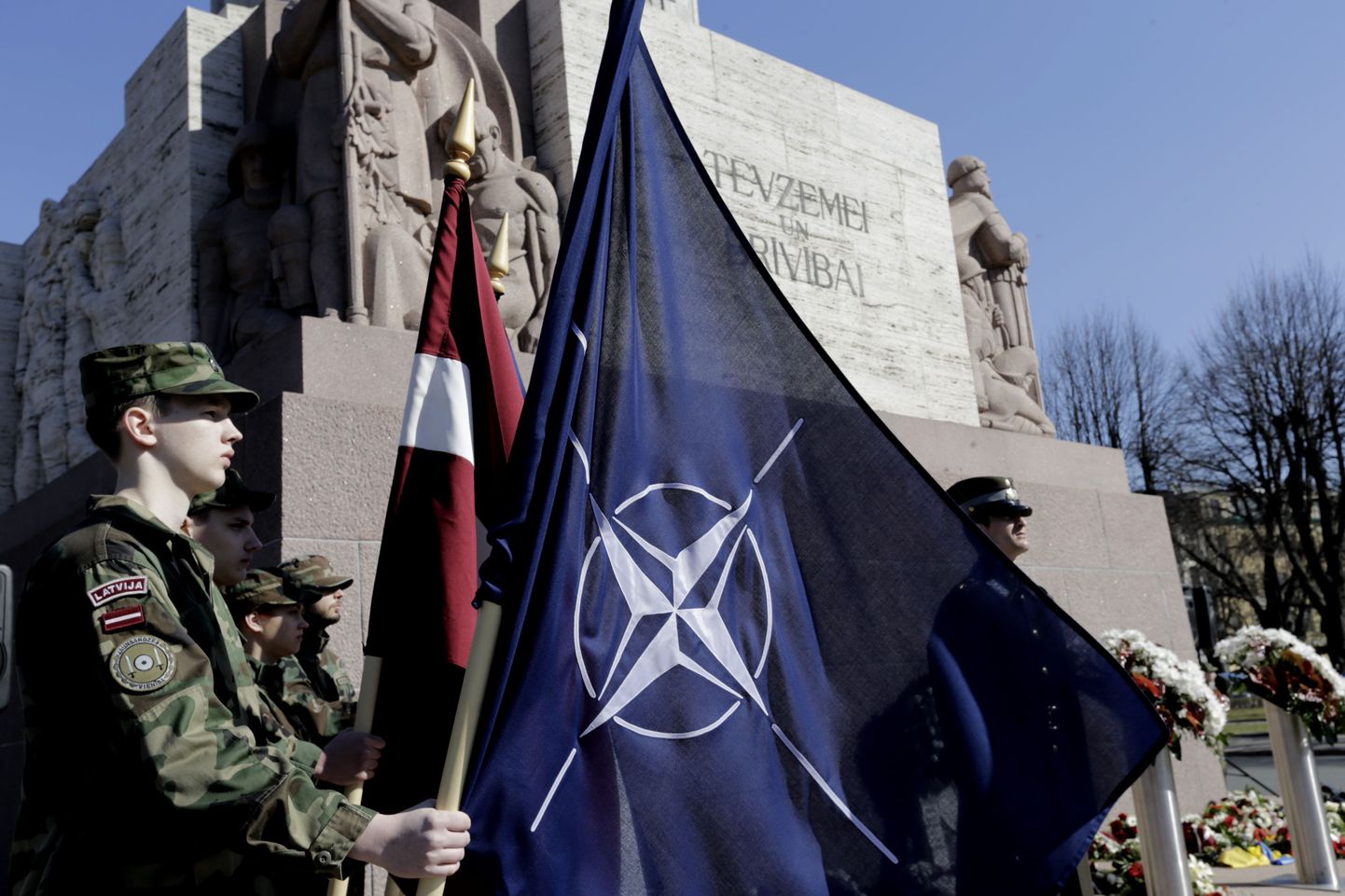 Läti sõdurid NATO ja Läti lippudega Riias.