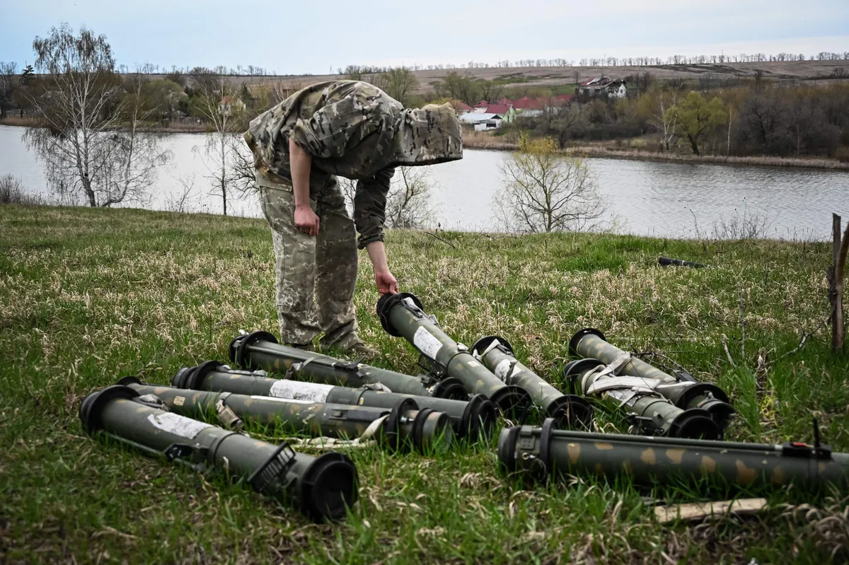 A Ukrainian serviceman examines remains of weapons at former position of Russian troops in the north of Kharkiv region.