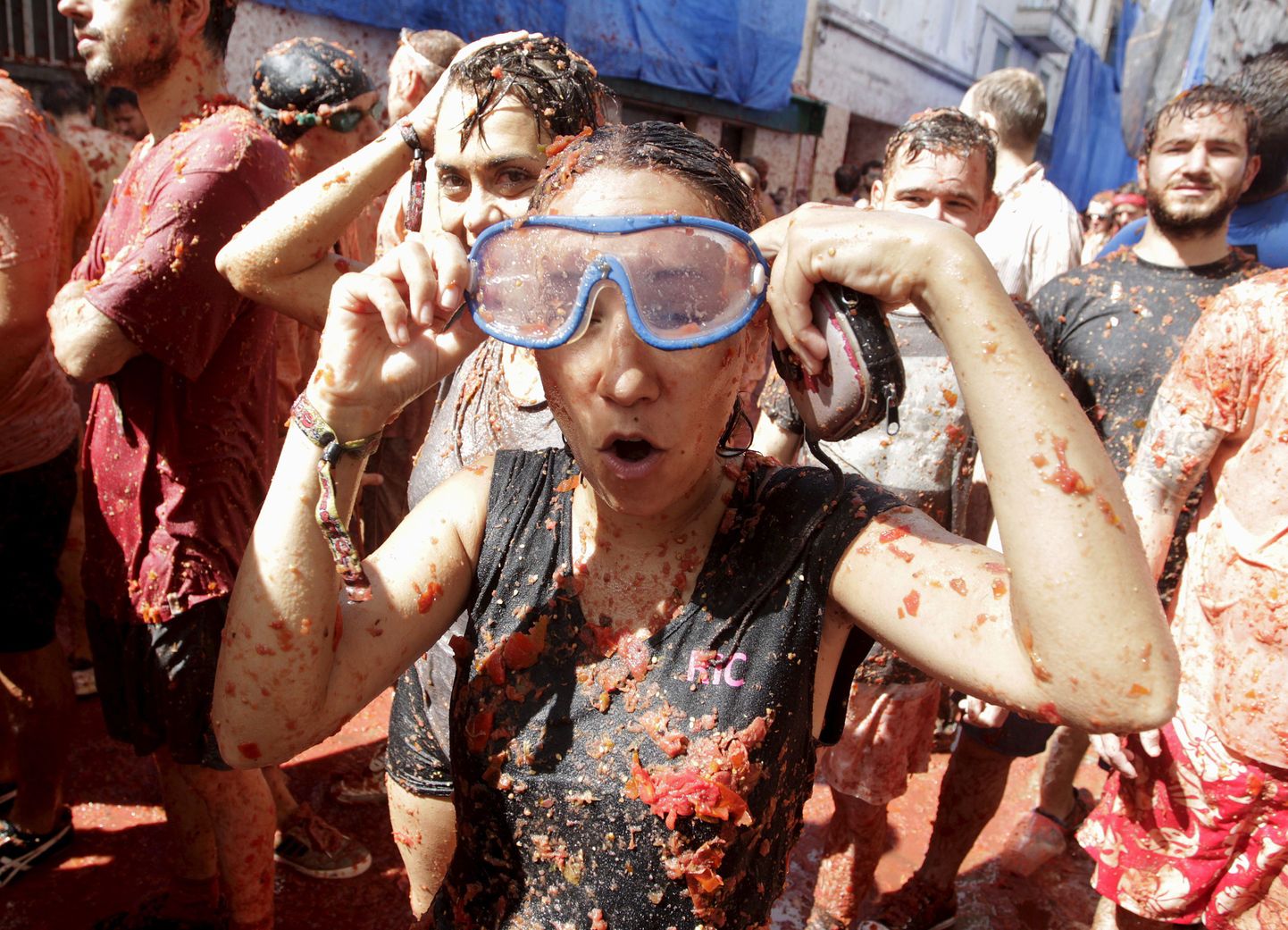 Revelers leave the "battlefield" after the annual "Tomatina" (tomato fight) in Bunol, near Valencia, Spain, August 26, 2015. Tens of thousands of festival-goers hurled 170 tonnes of over-ripe tomatoes at each other on Wednesday to celebrate the 70th anniversary of the massive food fight in the small village of Bunol in eastern Spain. REUTERS/Heino Kalis