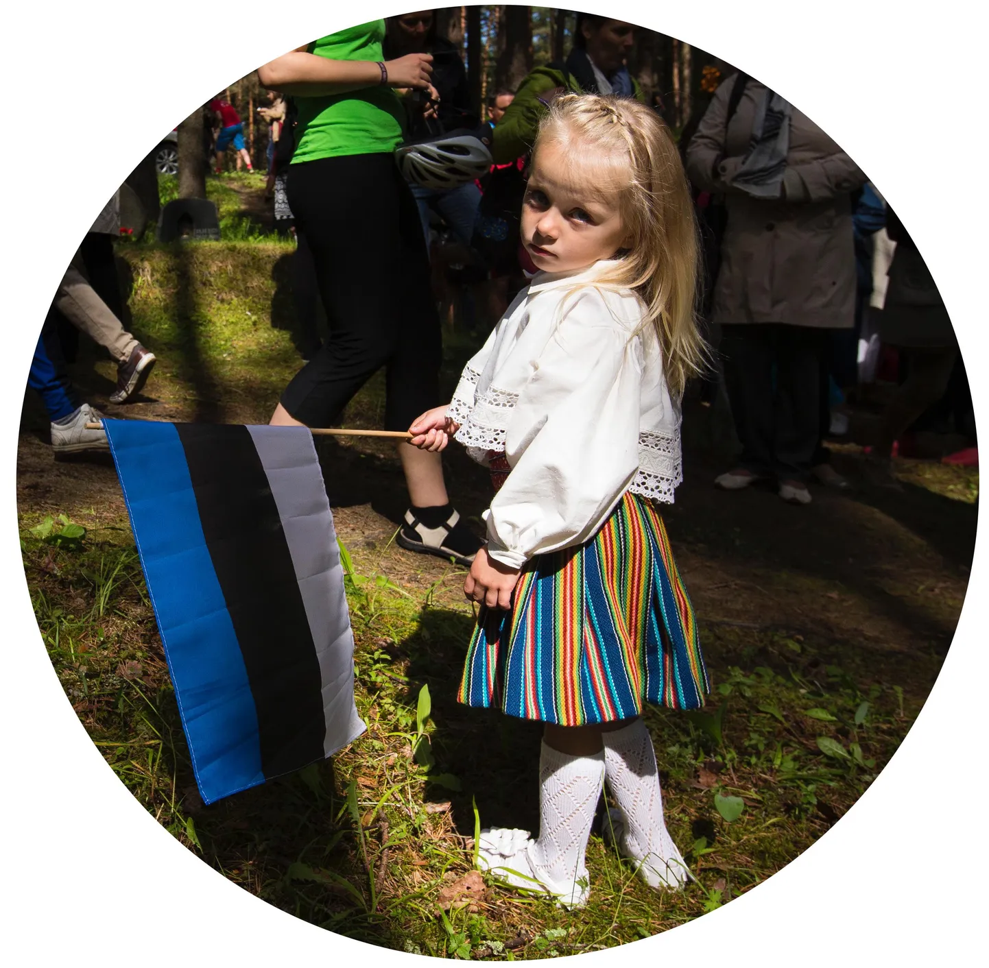 Väike laps rahvariietes ja eesti lipuga.