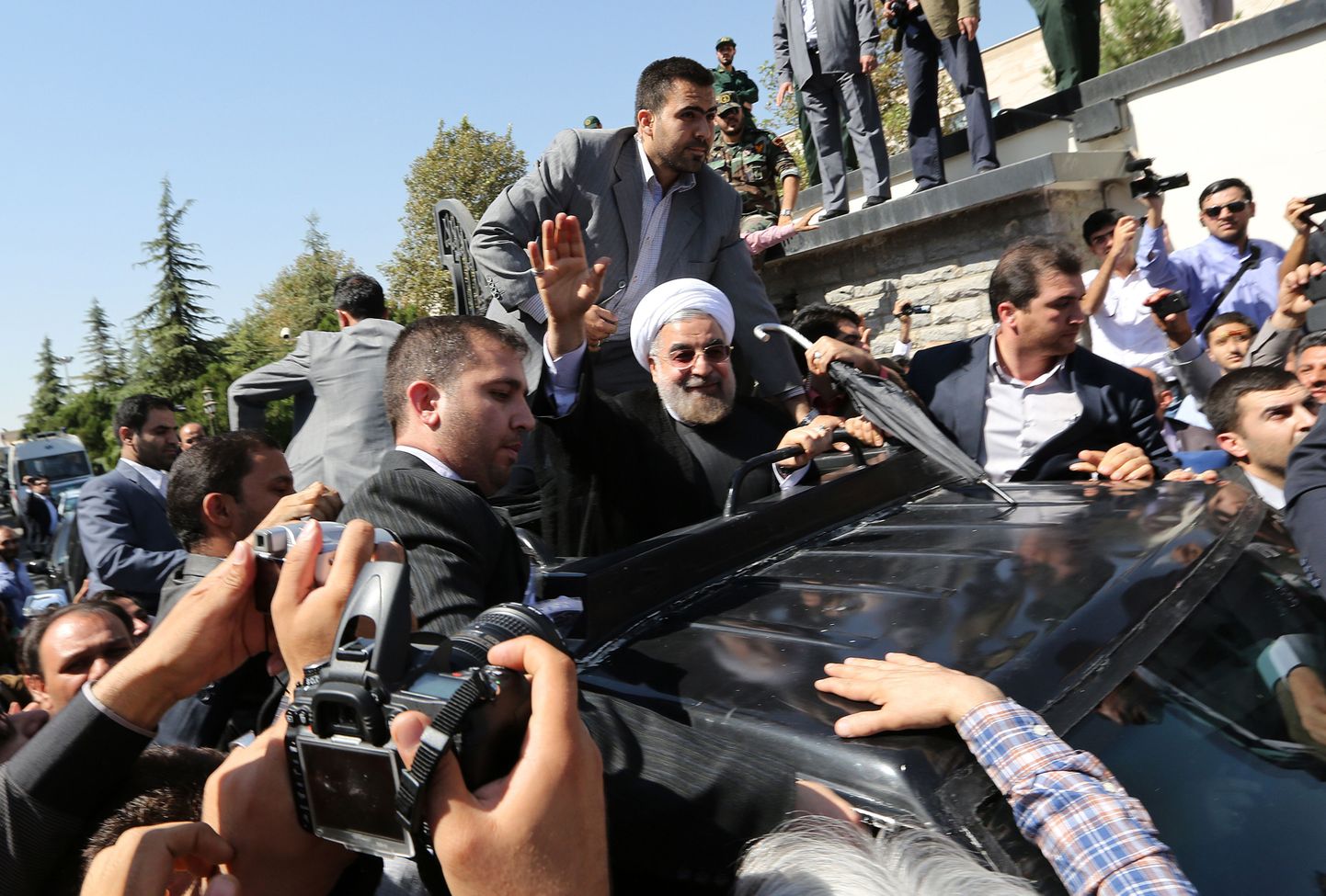 Iraani president Hassan Rowhani (keskel) upitas end auto katuseluugist välja ja lehvitas poolehoidjatele.