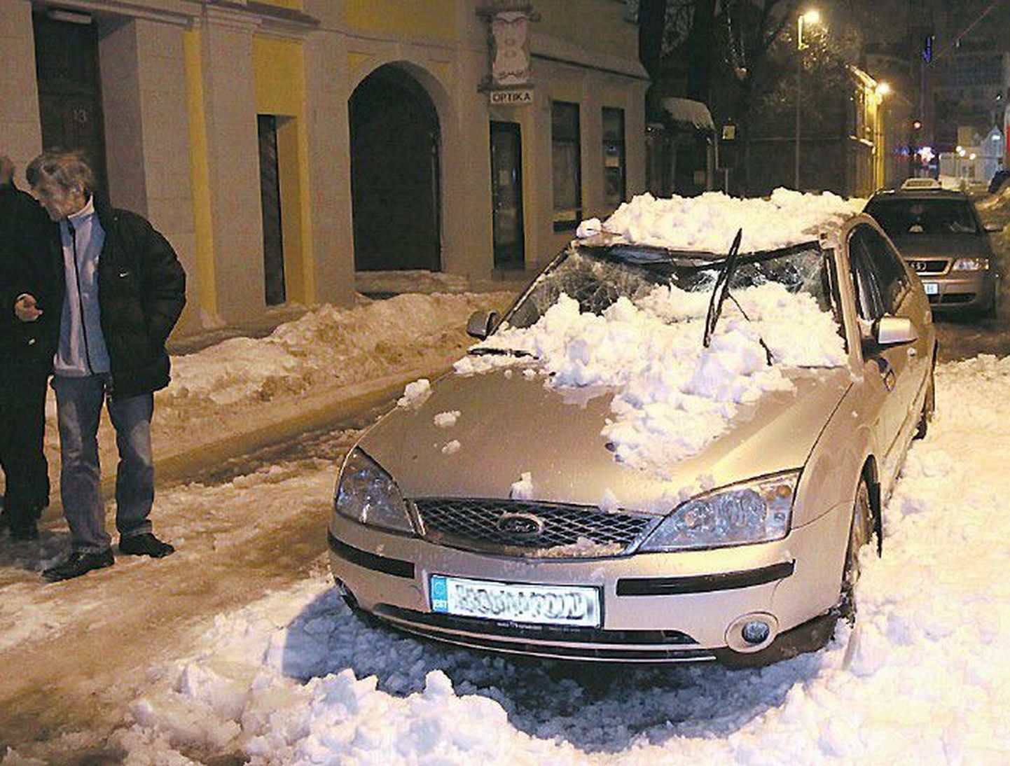 Автомобиль, припаркованный возле дома, пострадал от свалившегося с крыши снега.