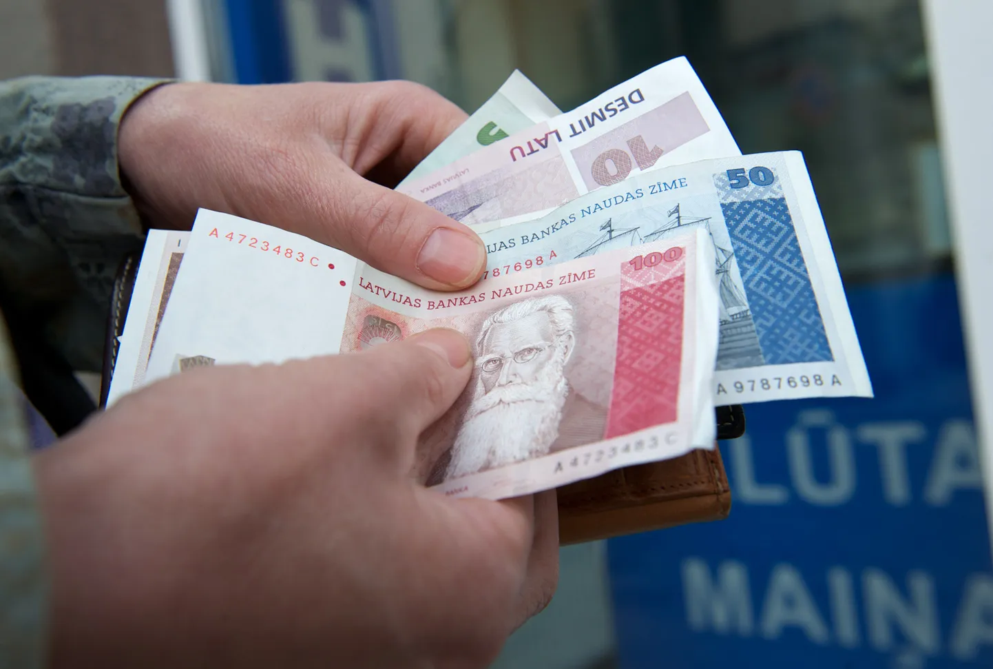 Naine täna Lätis valuutavahetuspunktis latti lugemas. Euroopa Komisjon andis täna Lätile rohelise tule tulevast aastast eurotsooniga liitumiseks.