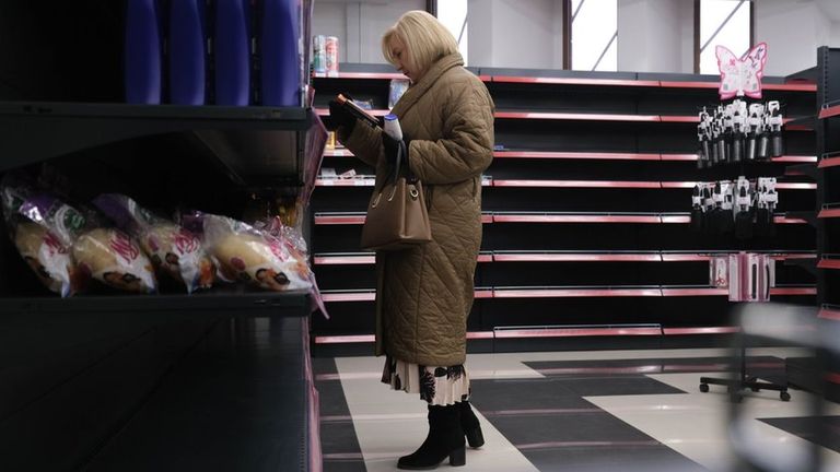 Женщина в магазине на фоне пустых полок