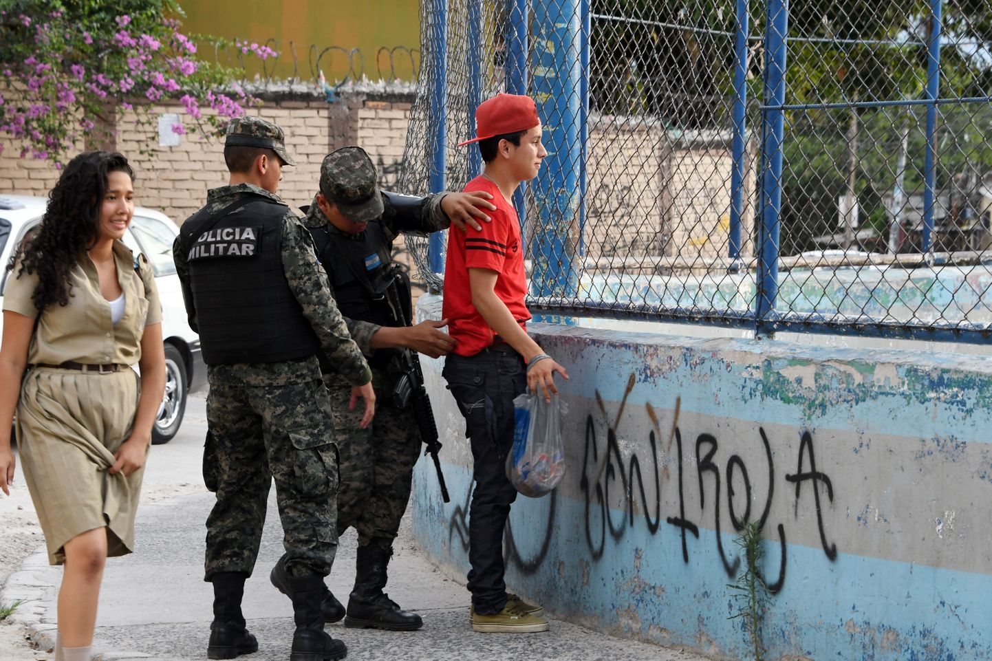 Hondurase sõjaväepolitsei kohalikku noormeest kontrollimas.