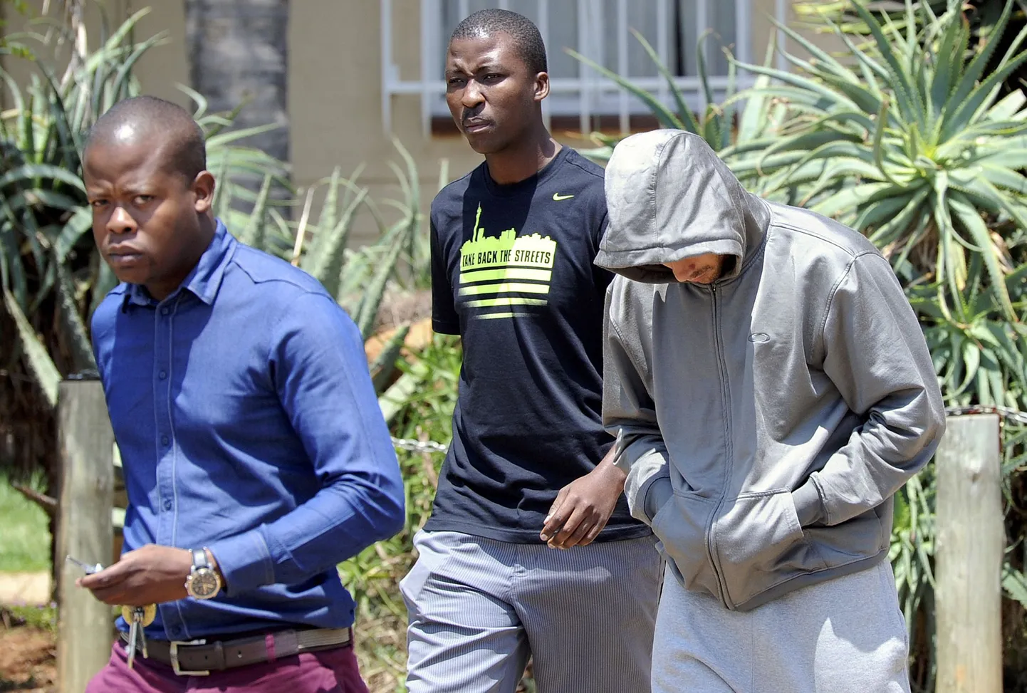 Oscar Pistorius (paremal) politseinike saatel politseijaoskonnast lahkumas. Just selle jaoskonna politseinikelt konfiskeeriti mobiiltelefonid.