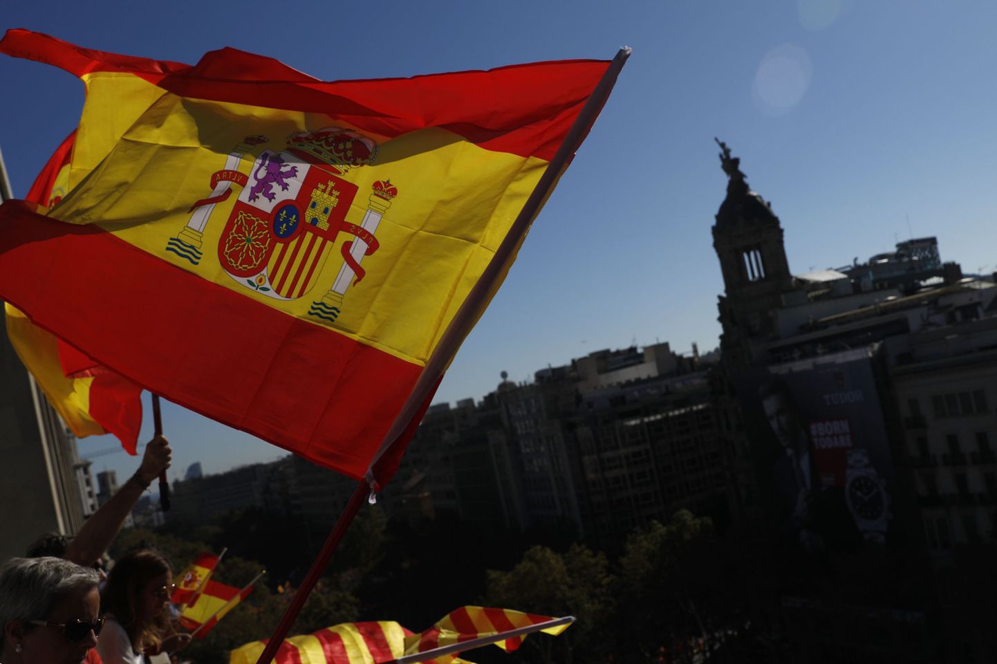 People wave Spanish and Catalan flags from a balcony during a mass rally against Catalonia's declaration of independence, in Barcelona, Spain, Sunday, Oct. 29, 2017. Thousands of opponents of independence for Catalonia are holding the rally on one of the city's main avenues after one of the country's most tumultuous days in decades. (AP Photo/Gonzalo Arroyo)