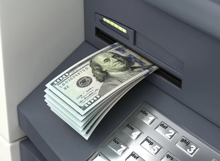 Sularahaautomaat ja dollarid. Pilt on illustreeriv