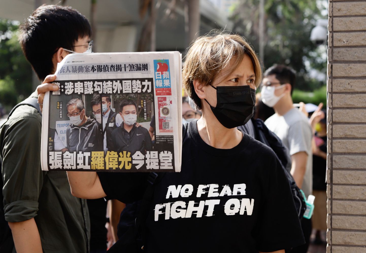 Hongkongi demokraatiameelse ajalehe Apple Daily toetaja kohtumaja ees, näitamas hommikust väljaannet, mille kaanel on ajalehe vahistatud tegevjuht ja peatoimetaja.