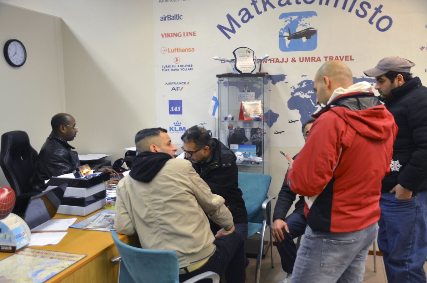 Soome saabunud migrandid reisibüroos Helsinkis uurimas tagasilennu võimaluste kohta Bagdadi.