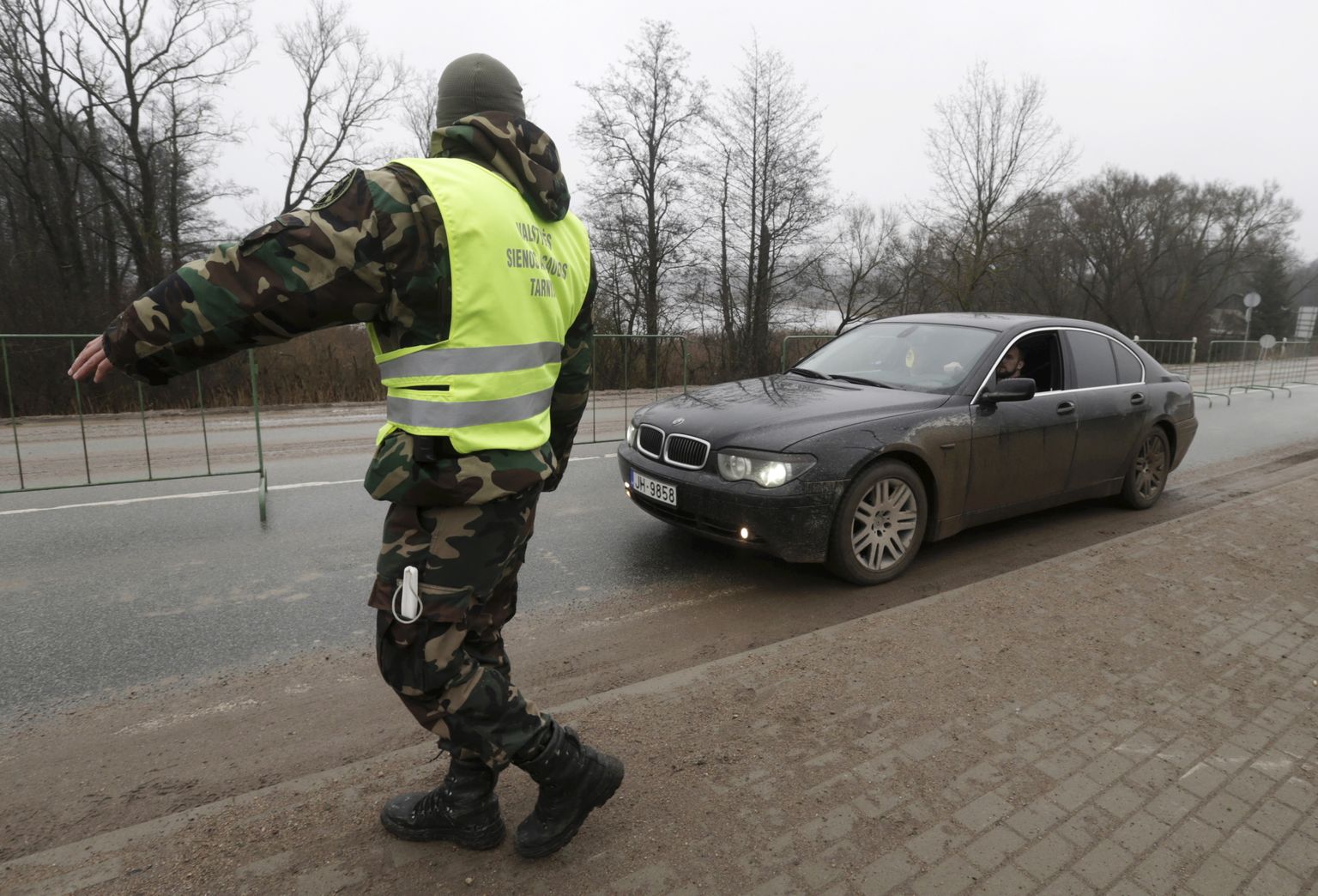 Leedu piirivalvur Läti piiril sõidukit peatamas.