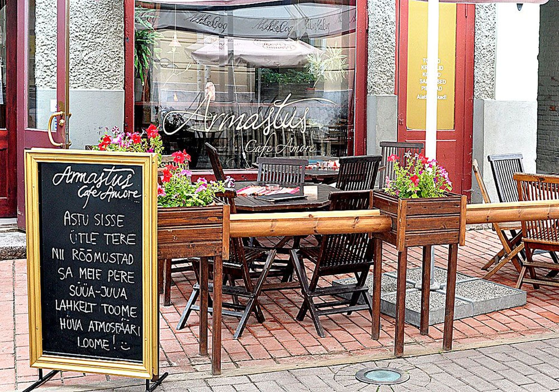 Rüütli tänaval asuva Balkani lauad, millel on ka restoranile viitavad sildid, seisavad kohviku Armastus ühe akna all.