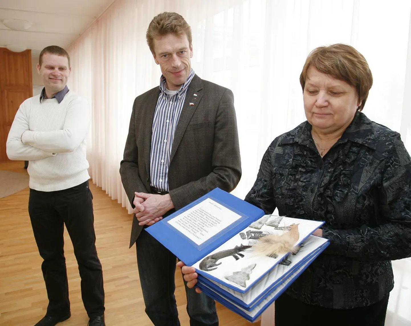 Mai tänava lasteaia juhataja Anne Virula näitab pimedatele lastele käsitsi valmistatud raamatut, mis on valminud Hamelni ja Pärnu lõviklubide koostöö projektina. Vasakul LC Pärnu president Romek Kosenkranius, tema kõrval väärtusliku kingituse rahastanud Hamelni LC president Stefan Rumen.