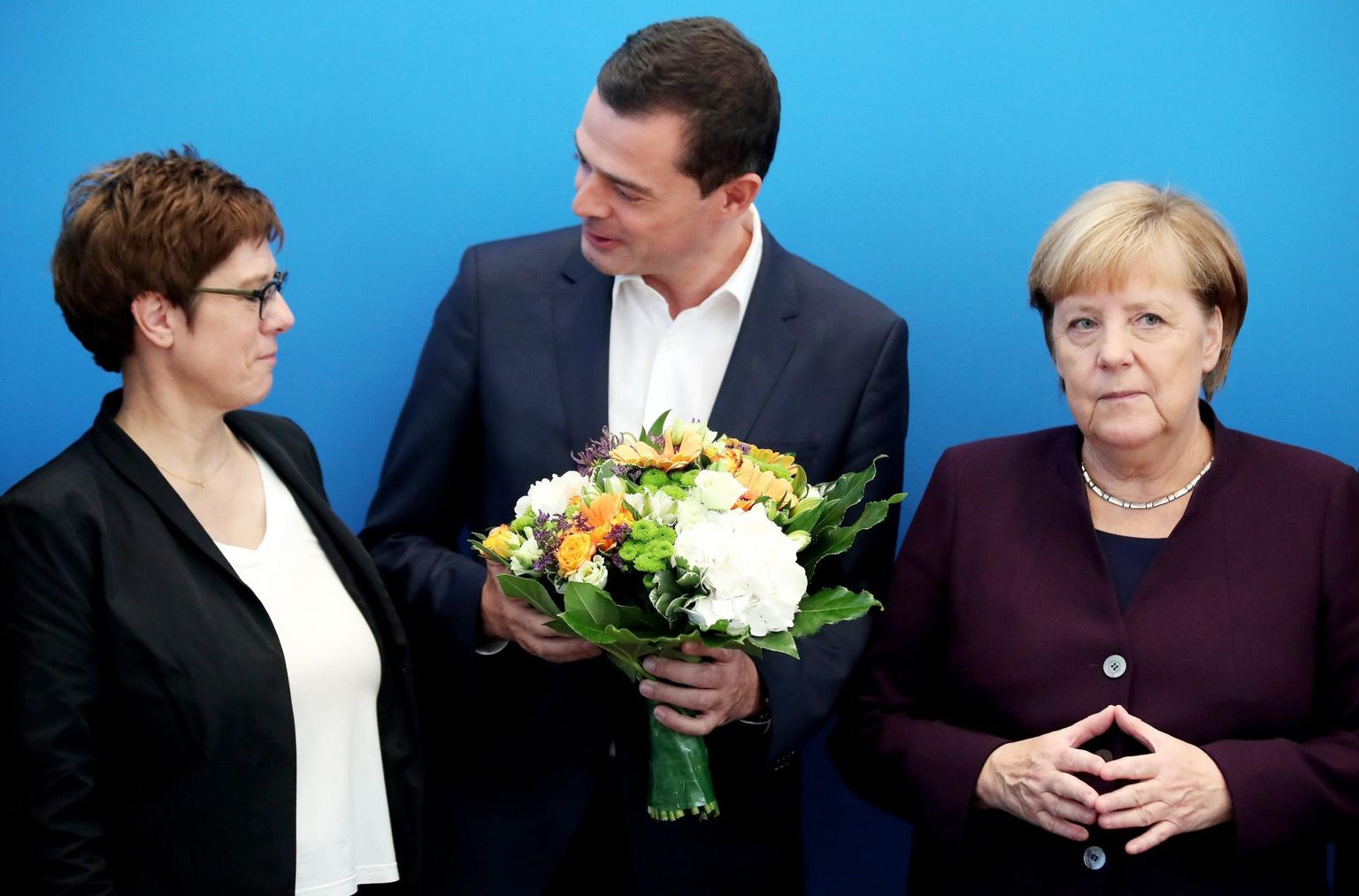 Kuigi Saksa konservatiivide juht Annegret Kramp-Karrenbauer (vasakul) ja liidukantsler Angela Merkel (paremal) ulatasid Tüüringi maapäeva valimiste järel sealsele esikandidaadile Mike Mohringile lillekimbu, polnud neil põhjust valimistulemuste üle rõõmustada. 