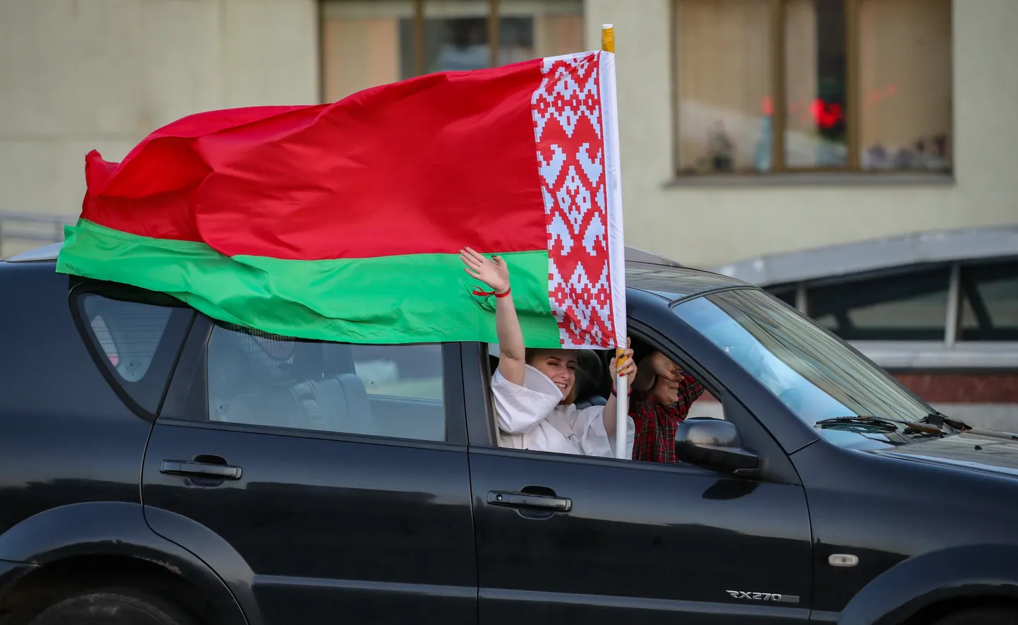 Люди в машине с флагом Беларуси