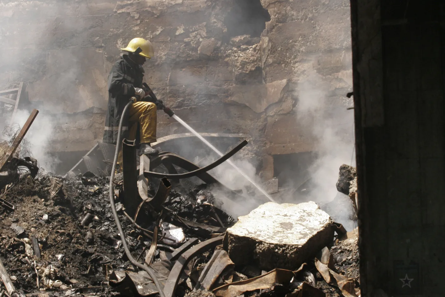 Nairobi tuletõrjujad maha põlenud Nakumatti kaubahalli suitsevatel rusudel.