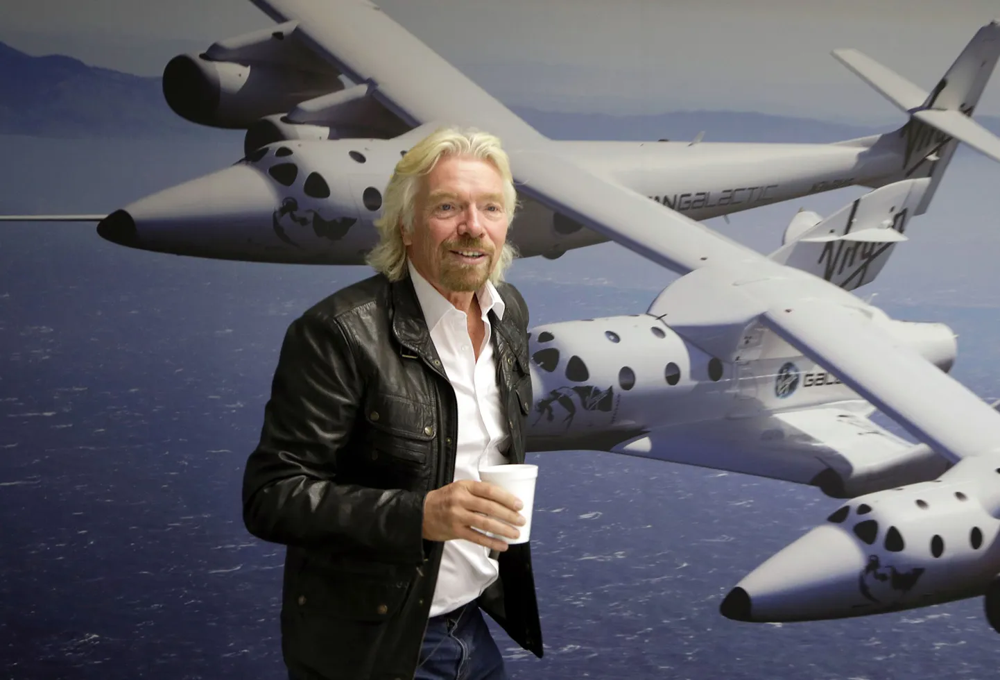 Richard Branson kosmoselaeva Virgin Galactic pildi juures.
