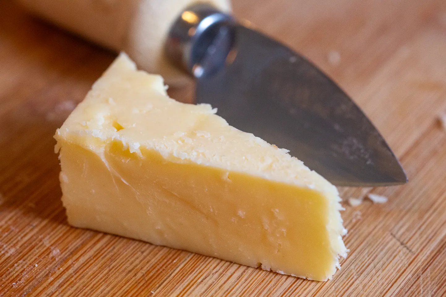 Cheddari juustu tükk lõikelaual.