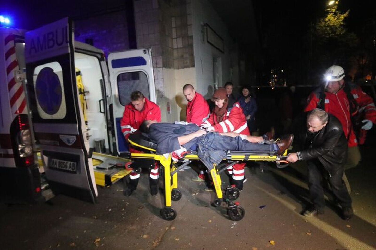 Медики погружают раненного в результате покушения в машину скорой помощи.