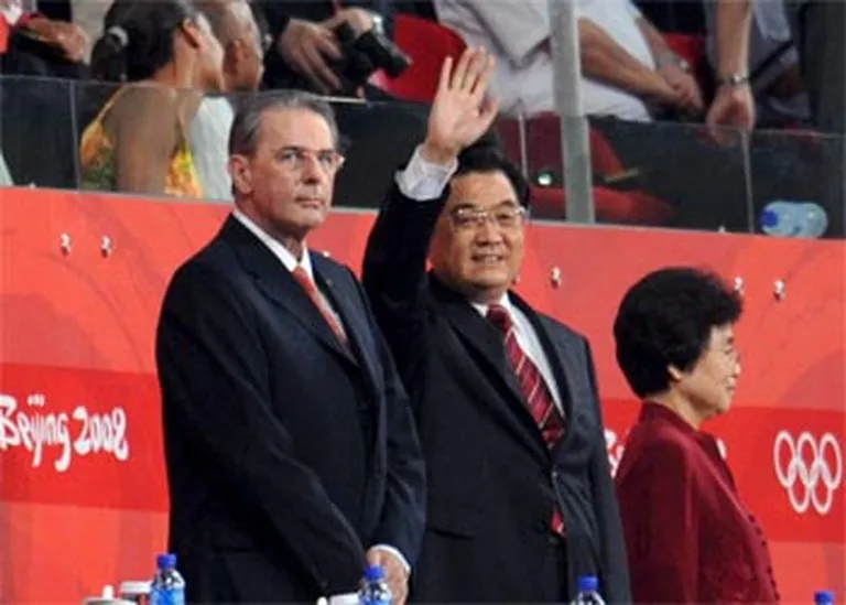 SOK prezidents Žaks Roge (pa kreisi) Pekinas olimpisko spēļu noslēguma ceremonijā līdzās Ķīnas prezidentam Hu Dzintao un viņa kundzei Li Jongkingai. 