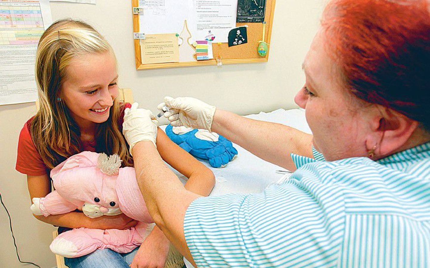 По словам медсестры Таллиннской 21-й школы Нины Плиско (справа), в школе сейчас хватает работы, поскольку они сами проводят вакцинацию и медосмотр тех школьников, которые не посещают семейного врача. На фото: медсестра вакцинирует ученицу 6-го класса Трийн Марлеэн Круузимяги.
