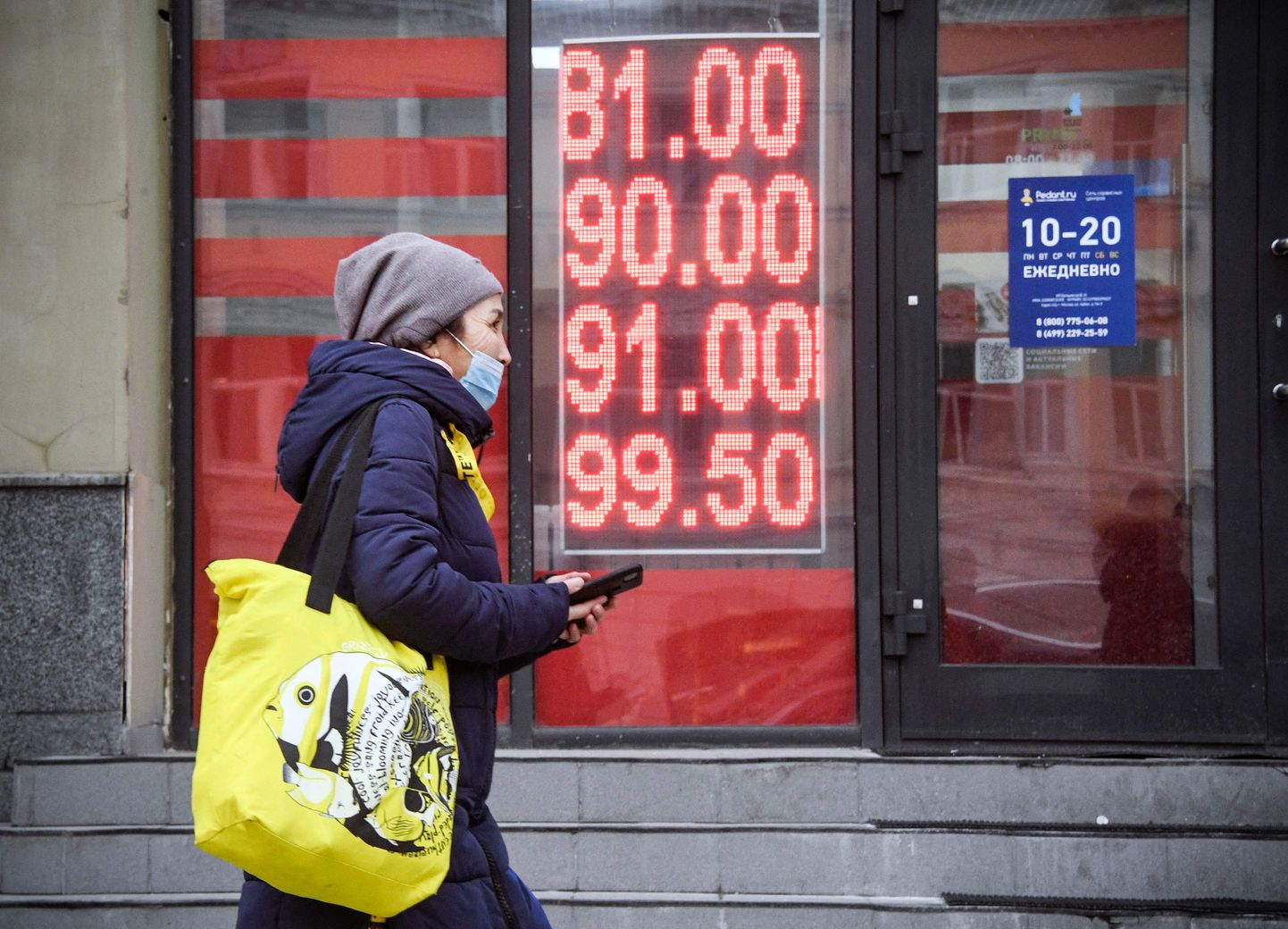 Sieviete iet gar valūtas maiņas punktu Maskavas centrā 2022. gada 24. februārī.