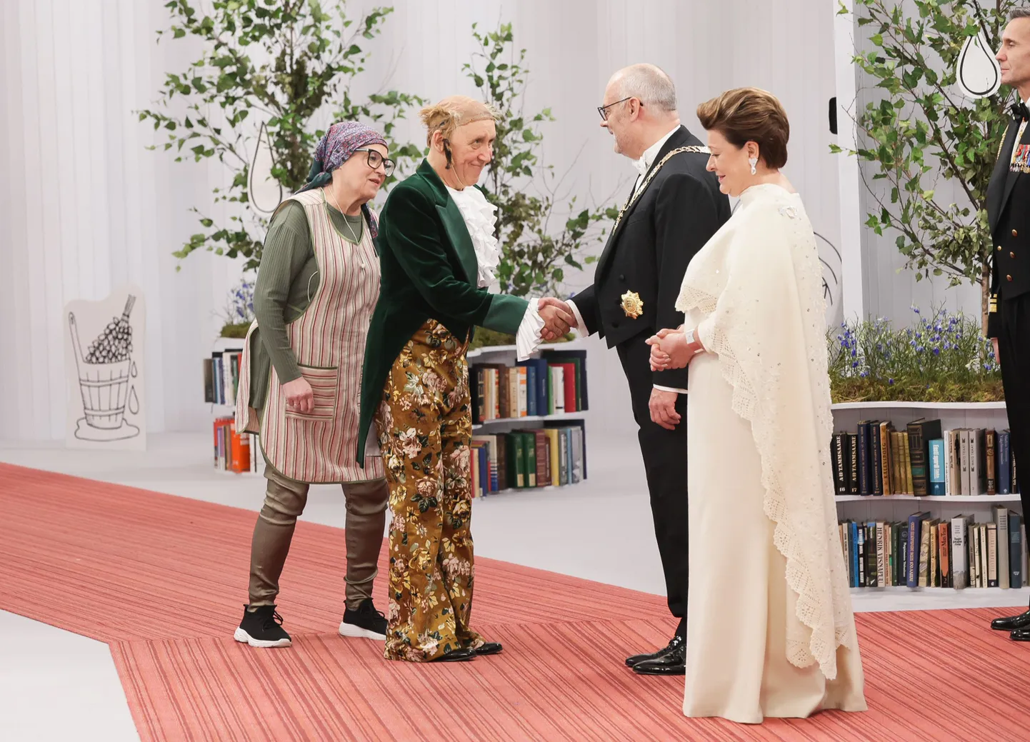 Kontsertetenduse lavastaja, Pantalone rollis lavale astunud Elmo Nüganen presidendipaariga tervitamas.