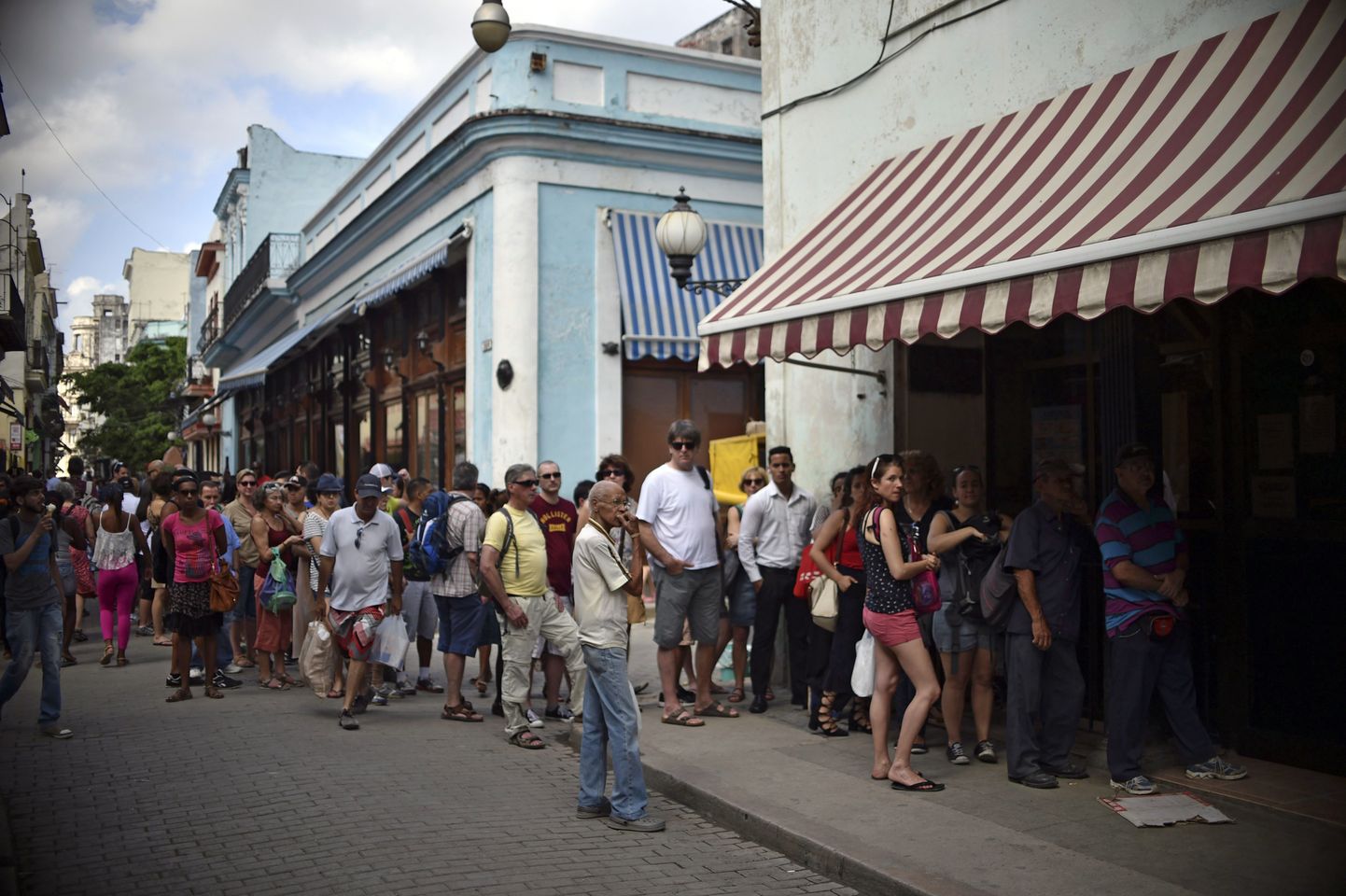 Turstid ja kuubalased ootavad pikas järjekorras Havanna Western Unioni kontori ukse taga, et reisitšekke rahaks vahetada.