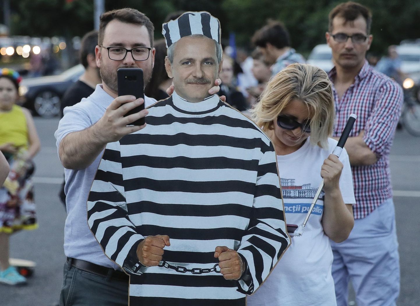 Liviu Dragnead vanglarüüs kujutava plakatiga meeleavaldajad mais Rumeenia valitsushoone juures protestimas. 