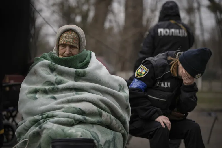 Ukraina politseinik nutab Kiievi lähedasest Irpinist evakueeritud eaka naise kõrval.