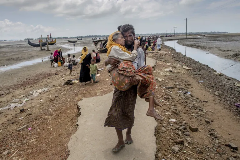 Bangladeshi põgenenud rohingja oma ema põgenikelaagrisse kandmas.