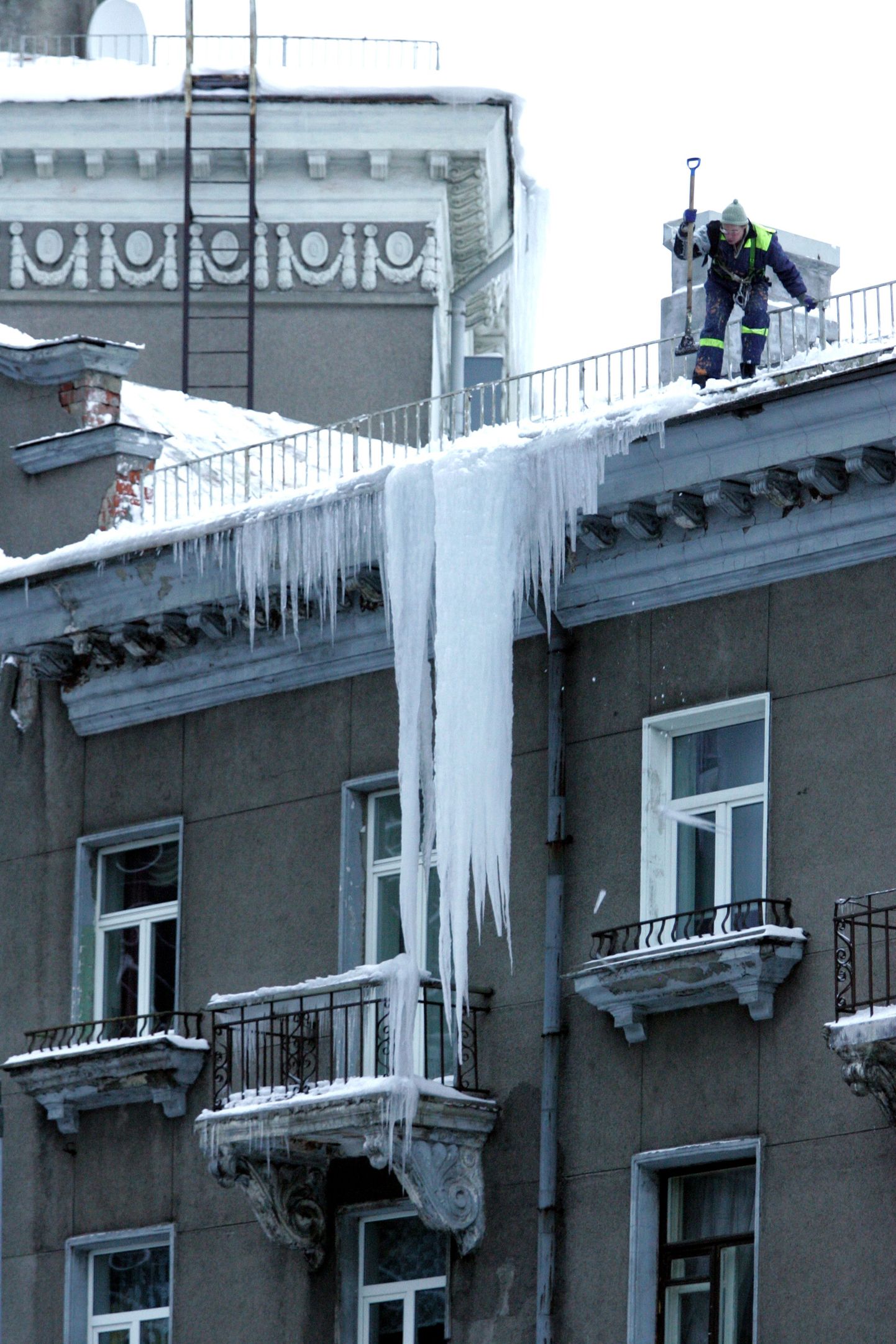 Jääpurikate lõhkumine Tartu maantee ja Liivalaia tänava ristmikul asuva torniga maja katusel.