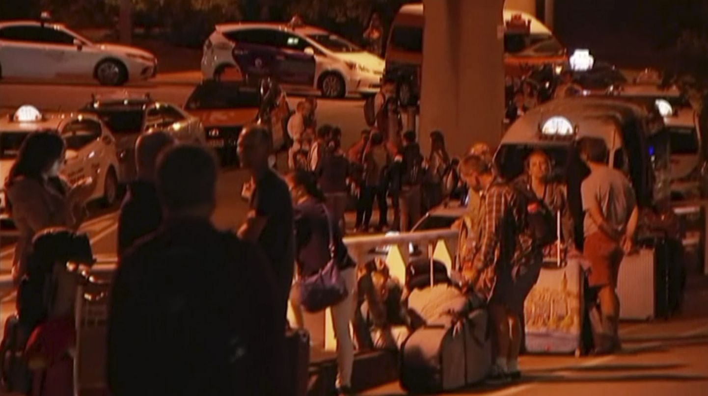 Reisijad Brisbane'i lennujaama lähedal tänaval ootamas.