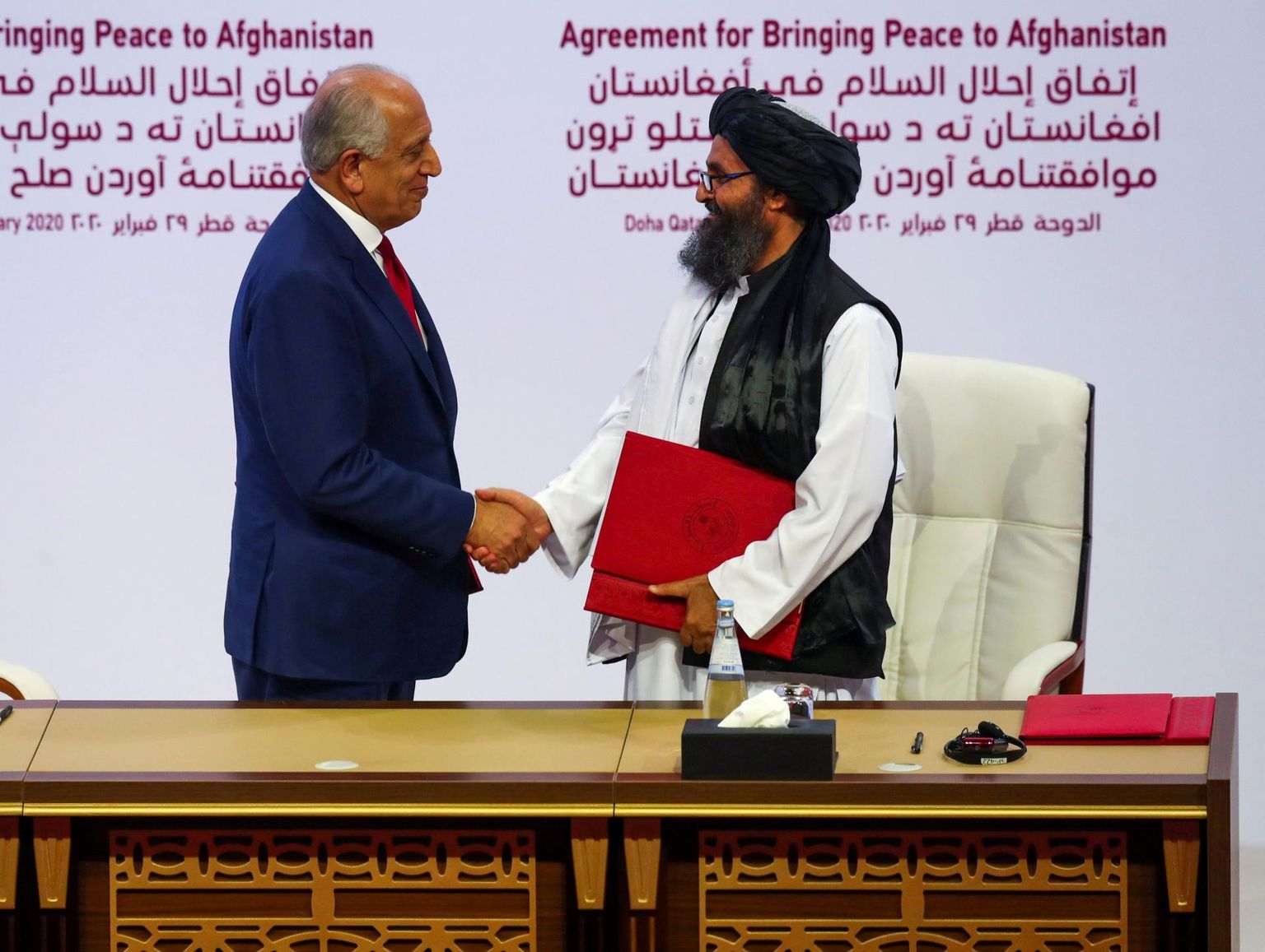 USA erisaadik Afganistani küsimustes Zalmay Khalilzad (vasakul) ja Talibani kaasasutaja mulla Abdul Ghani Baradar sõlmimas ajaloolist rahulepet.