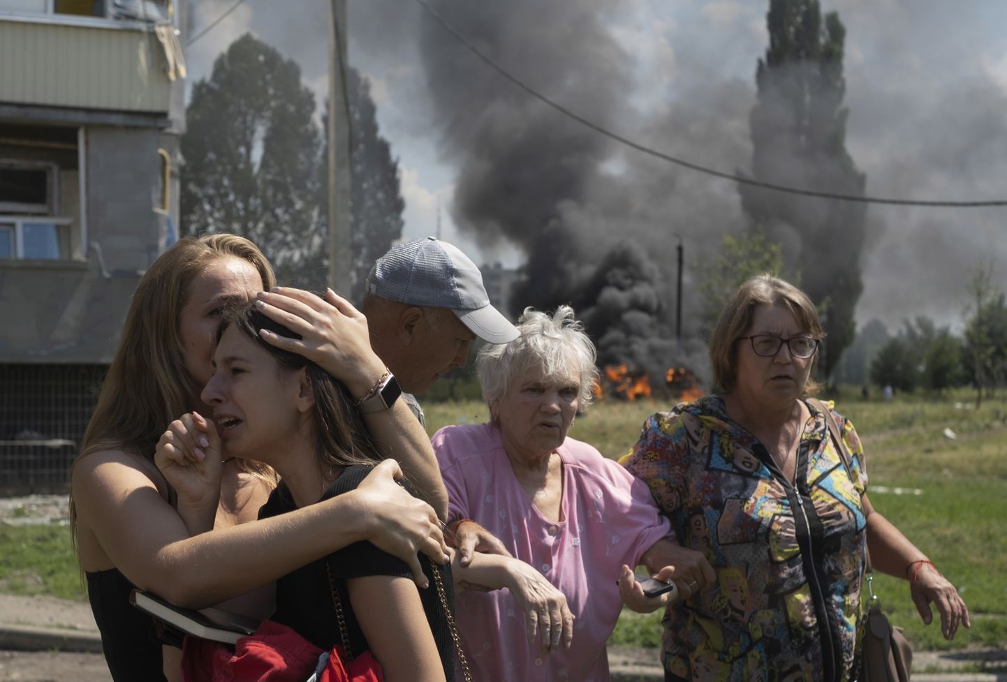Местные жители на месте ракетного обстрела поселка Первомайский в Харьковской области, 4 июля 2023 года. По данным ГСЧС тогда пострадал 31 человек, в том числе девять детей.