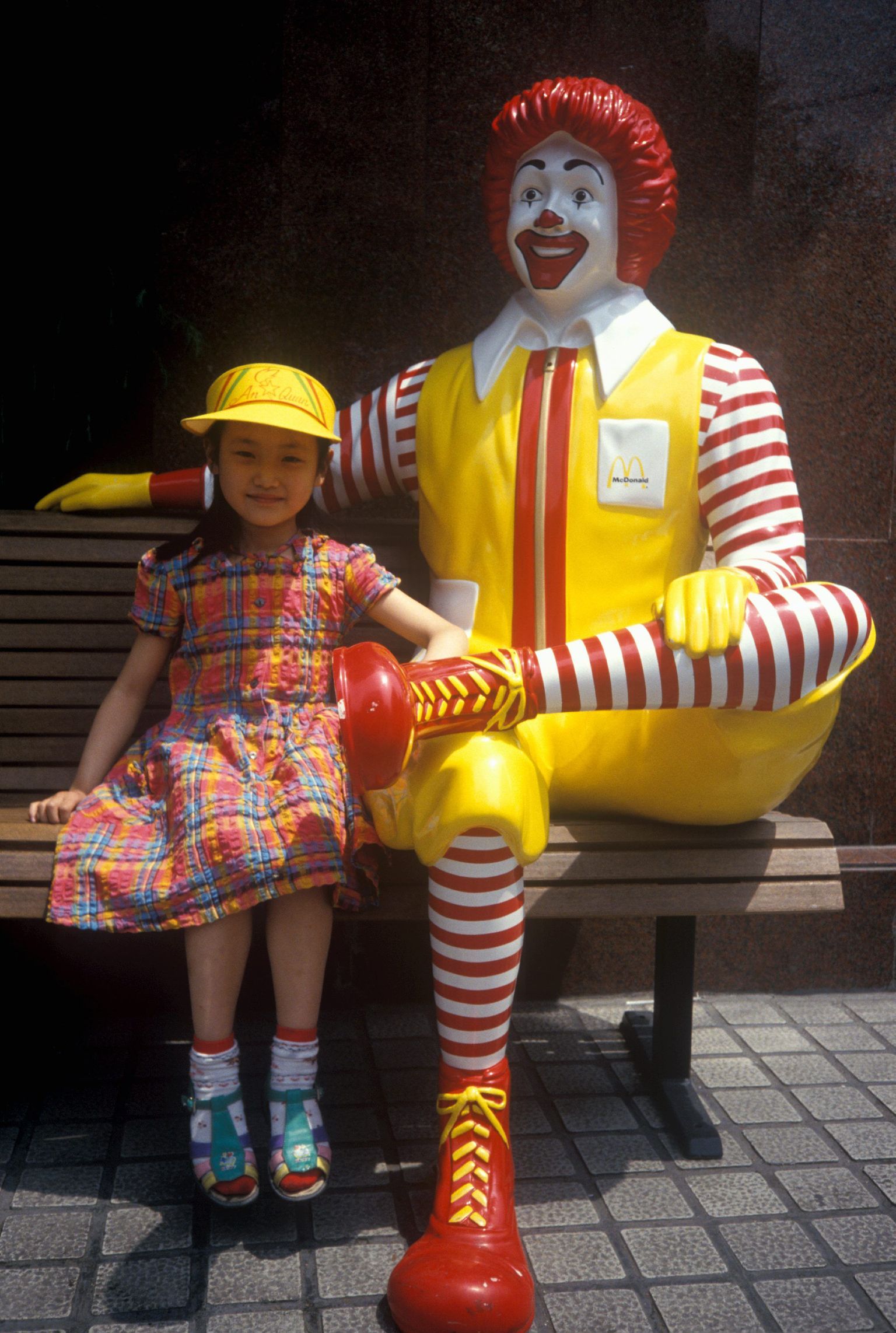 McDonald`si maskott Ronald McDonald koos väikese tüdrukuga.