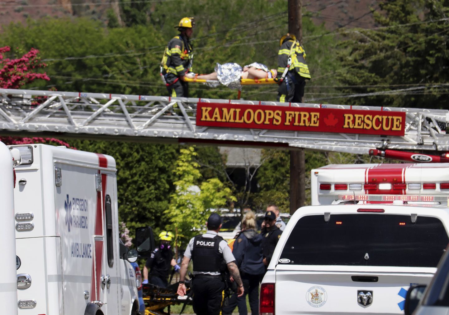 Päästetöötajad toovad lennuõnnetuses viga saanud piloodi majakatuselt alla.
