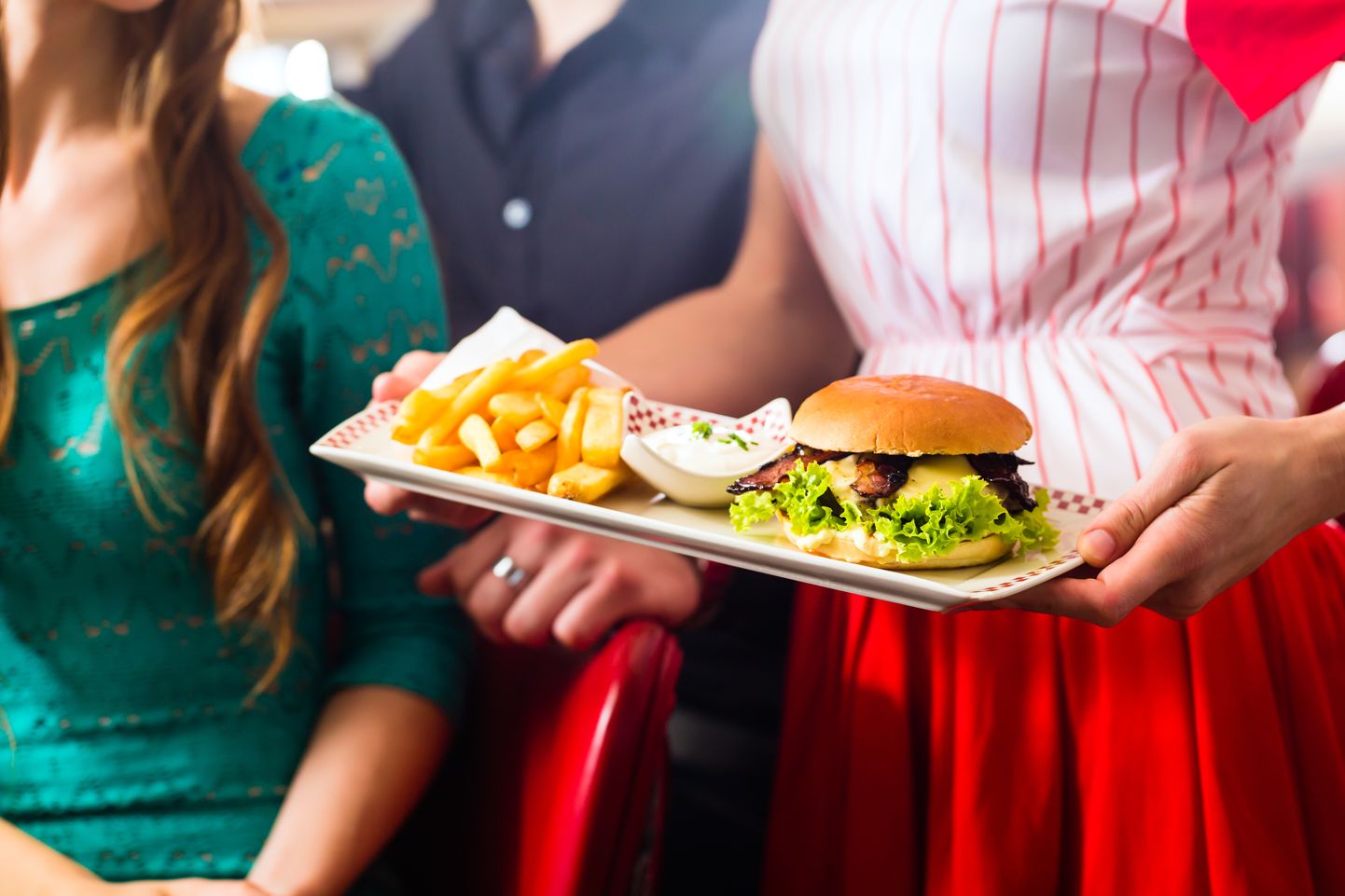 People in American diner or restaurant eating burger