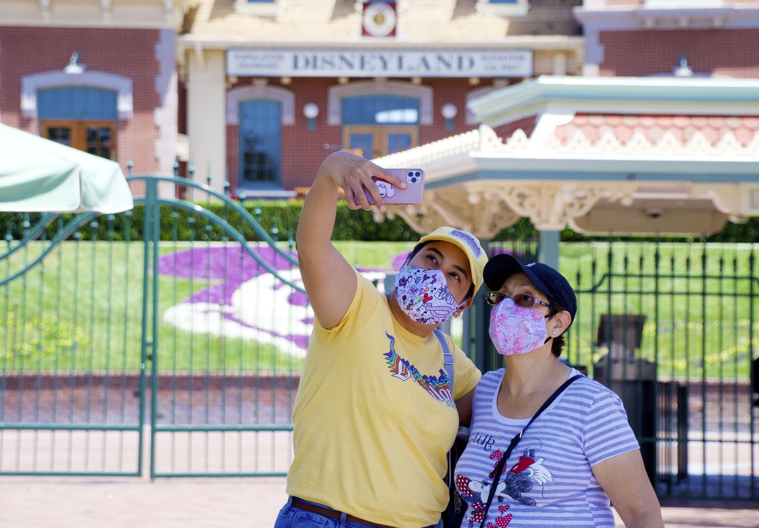 Maskides külastajad Disneylandi sissepääsu juures pargi üldala avamispäeval Anaheimis, Californias – nädalavahetusel avatakse koroonaviiruse kiuste uksed ka Floridas.