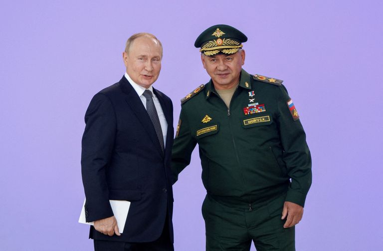 Сергей Шойгу трогает Путина сзади на церемонии открытия международного военно-технического форума "Армия-2022", Московская область, 15 августа 2022 года.