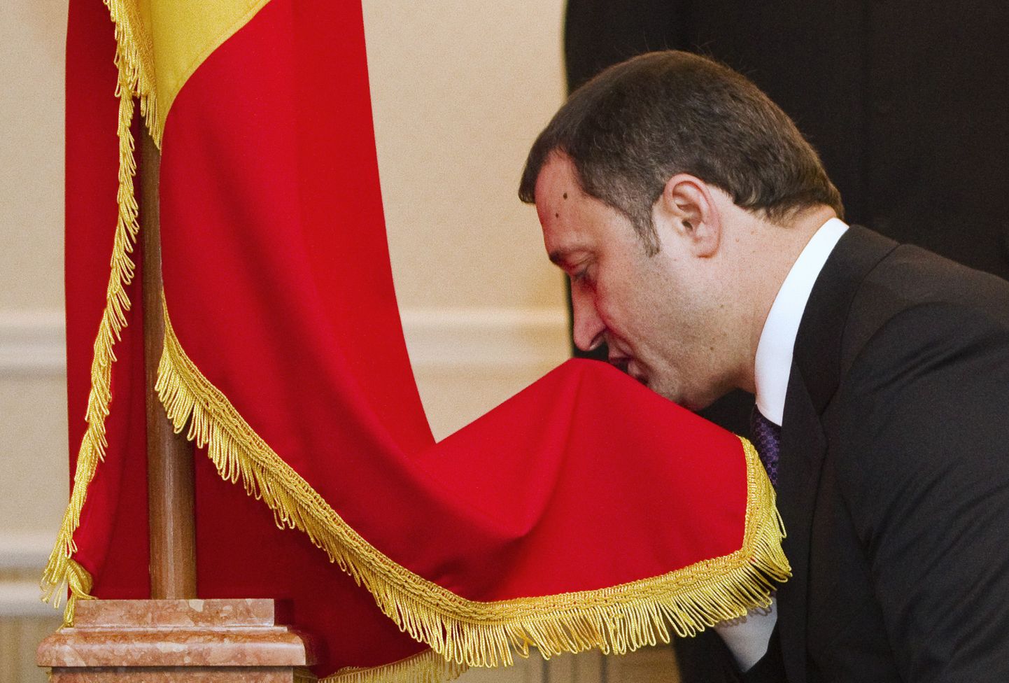 Täna uuesti ametisse vannutatud Moldova peaminister Vlad Filat suudlemas riigilippu.