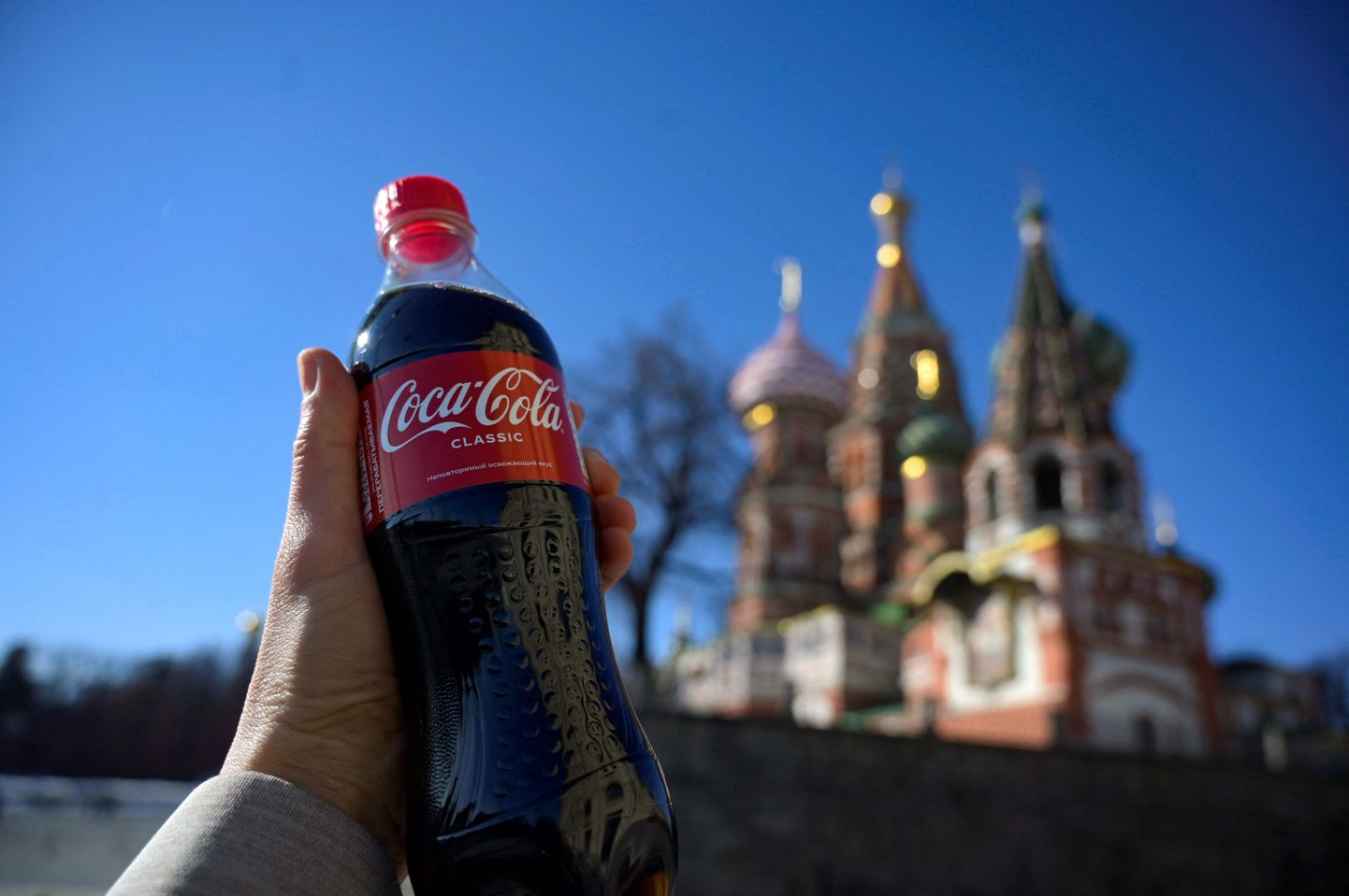 Inimene hoidmas Moksvas märtsis Coca-Cola pudelit. Coca-Cola kompanii lahkus Venemaalt ja venelased hakkasid tootma selle firma karastusjookidega sarnaseid karastusjooke
